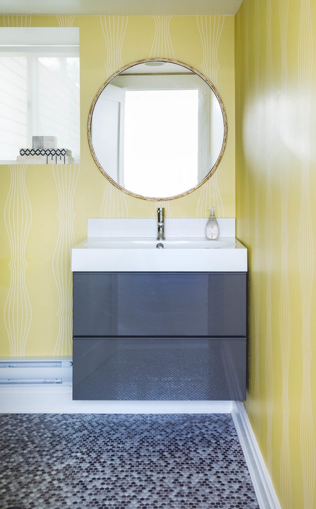 Идея дизайна: ванная комната среднего размера в современном стиле с монолитной раковиной, плоскими фасадами, серыми фасадами, столешницей из искусственного камня, серой плиткой, керамической плиткой, желтыми стенами, полом из мозаичной плитки и разноцветным полом