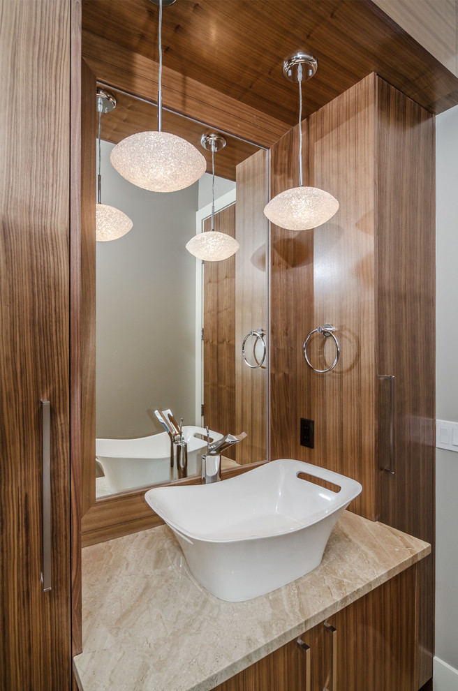 Inspiration pour une salle de bain design en bois brun avec une vasque, un placard à porte plane et un mur gris.
