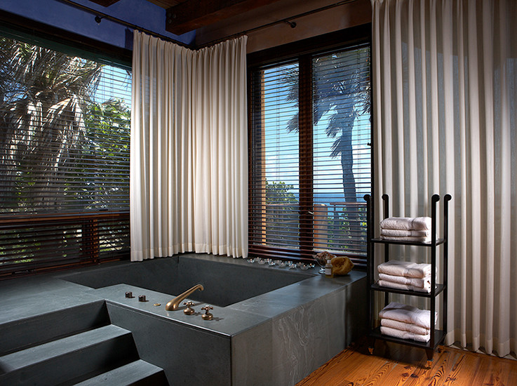 Diseño de cuarto de baño principal marinero grande con bañera esquinera, paredes azules, suelo de madera en tonos medios, armarios con paneles lisos y puertas de armario de madera oscura