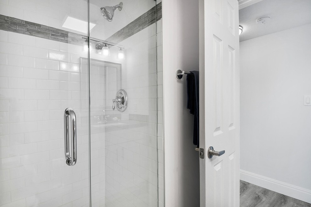 Idéer för ett mellanstort maritimt grå badrum med dusch, med luckor med infälld panel, vita skåp, en dusch i en alkov, en toalettstol med hel cisternkåpa, vit kakel, tunnelbanekakel, grå väggar, ett undermonterad handfat, bänkskiva i kvarts och dusch med gångjärnsdörr