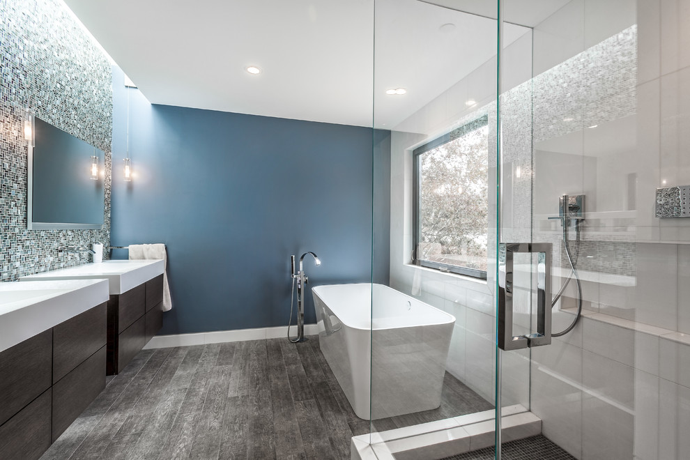 Inspiration för ett funkis en-suite badrum, med släta luckor, skåp i mörkt trä, ett fristående badkar, keramikplattor, blå väggar och klinkergolv i keramik