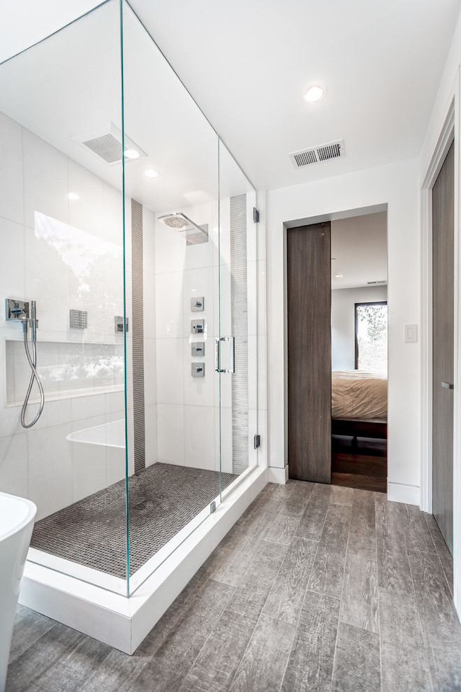 This is an example of a modern ensuite bathroom in San Francisco with flat-panel cabinets, dark wood cabinets, a freestanding bath, ceramic tiles, white walls and ceramic flooring.