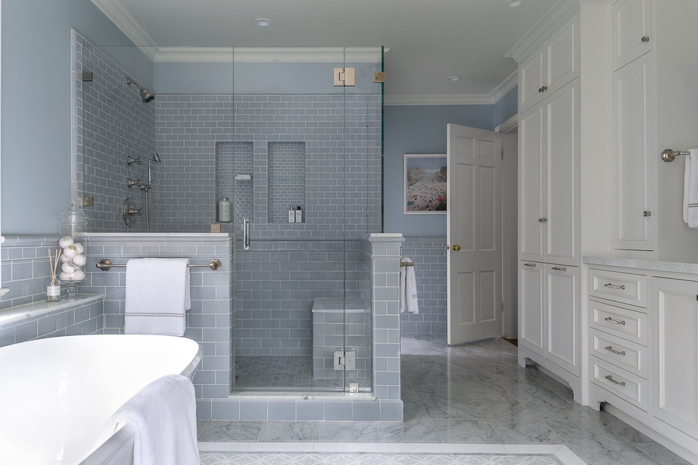 Пример оригинального дизайна: ванная комната в классическом стиле с фасадами с утопленной филенкой, белыми фасадами, отдельно стоящей ванной, угловым душем, синей плиткой, плиткой кабанчик, синими стенами, серым полом, душем с распашными дверями и белой столешницей