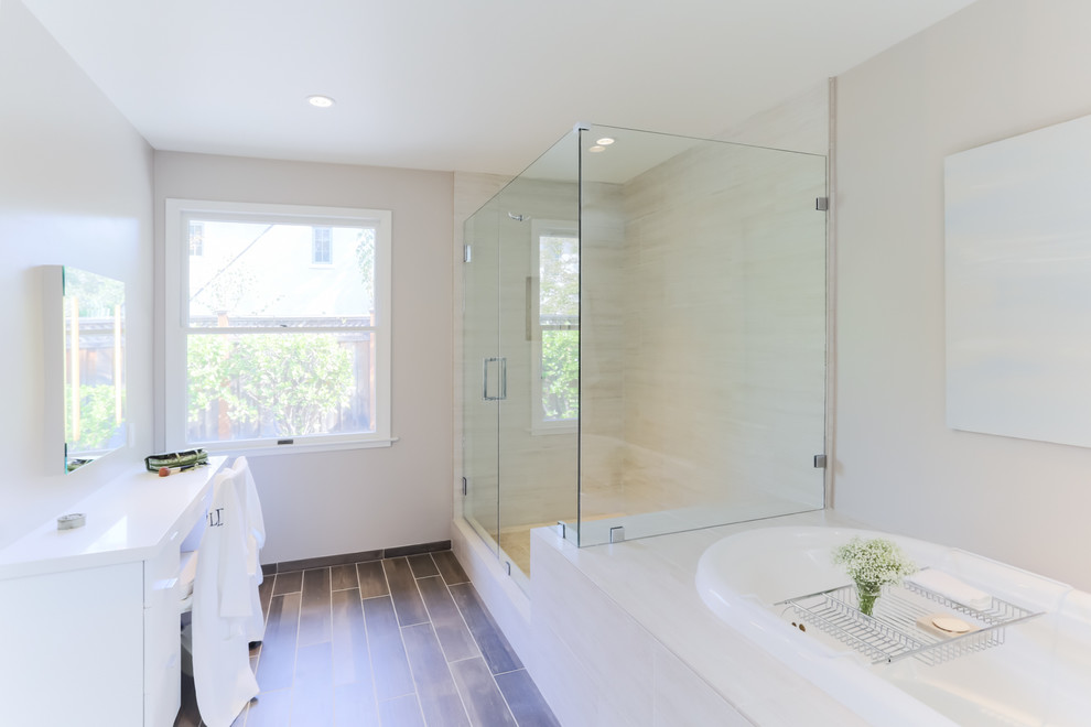 Photo of a large traditional ensuite bathroom in San Francisco with flat-panel cabinets, white cabinets, quartz worktops, a built-in bath, a corner shower, a two-piece toilet, beige tiles, slate tiles, white walls, medium hardwood flooring, a submerged sink, brown floors and a hinged door.