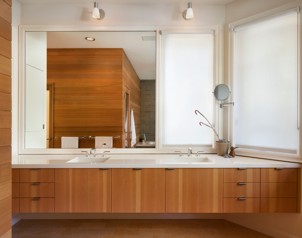 Foto di una grande stanza da bagno padronale minimal con lavabo integrato, ante lisce, ante in legno chiaro, top in quarzo composito e pareti bianche