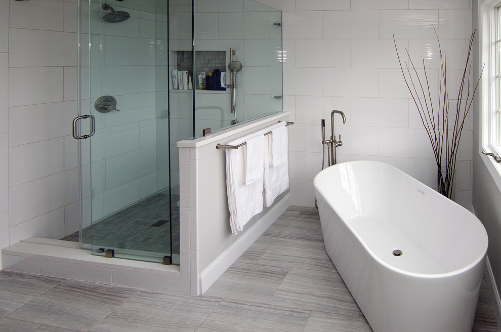 На фото: большая главная ванная комната в современном стиле с фасадами в стиле шейкер, серыми фасадами, отдельно стоящей ванной, угловым душем, унитазом-моноблоком, белой плиткой, керамогранитной плиткой, серыми стенами, полом из керамогранита, врезной раковиной, столешницей из кварцита, бежевым полом и душем с распашными дверями с