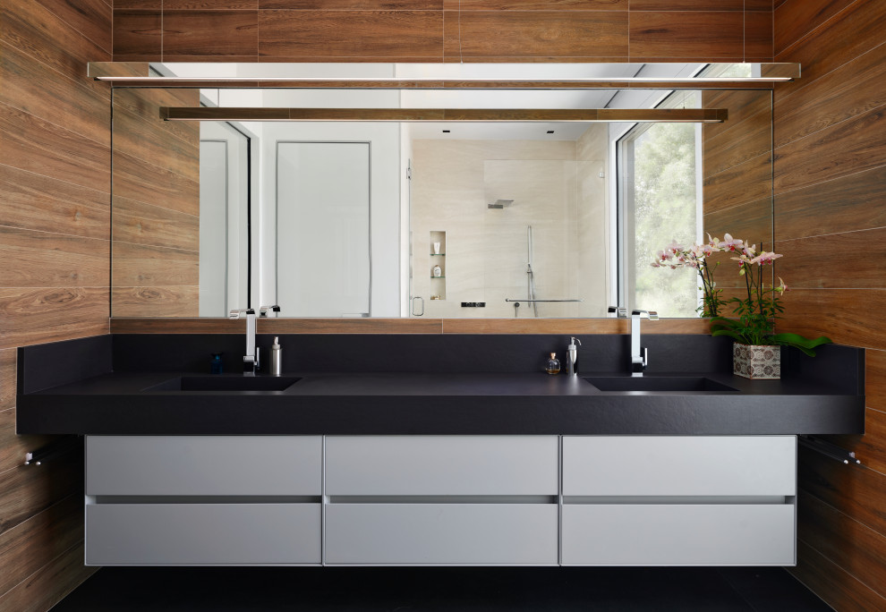 Inspiration för mellanstora moderna svart en-suite badrum, med släta luckor, brun kakel, klinkergolv i keramik, ett integrerad handfat, bänkskiva i kvarts, svart golv, vita skåp och bruna väggar