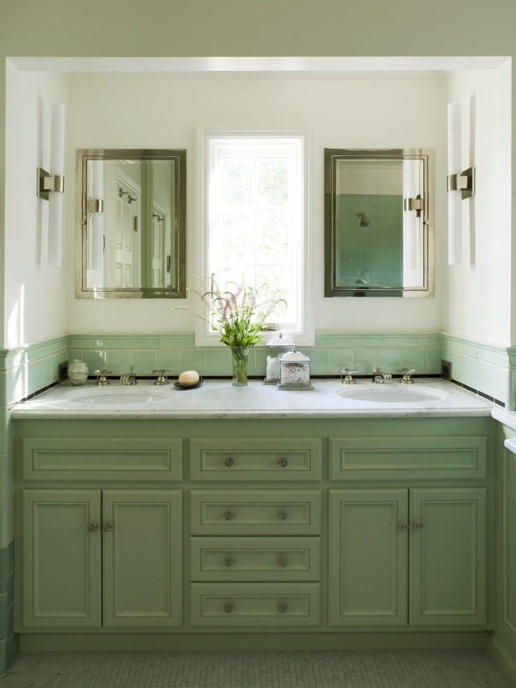 Imagen de cuarto de baño tradicional con encimera de mármol, puertas de armario verdes y ventanas