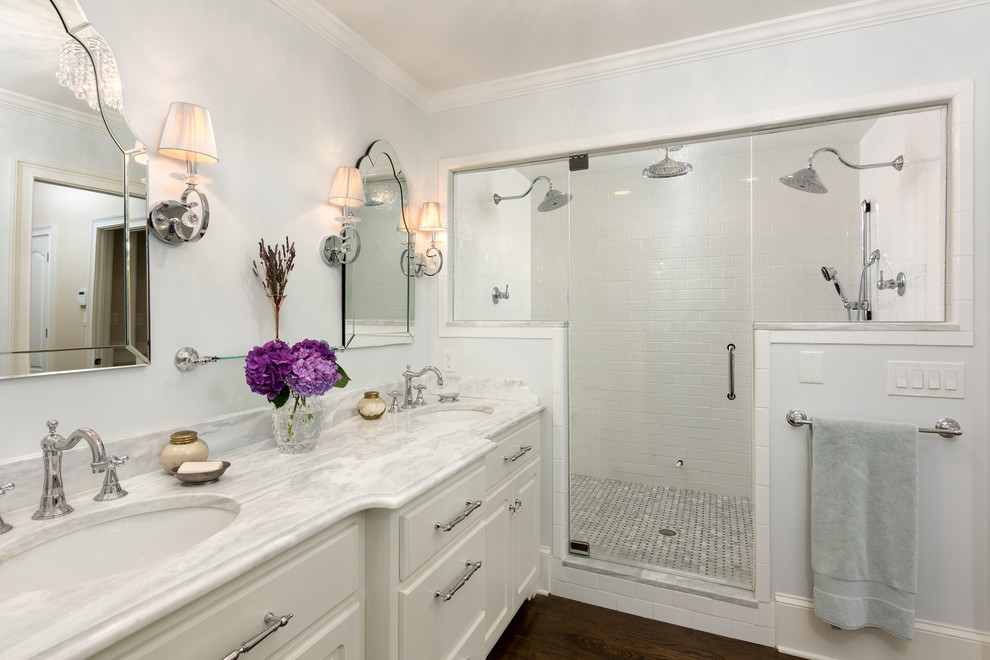 アトランタにあるトラディショナルスタイルのおしゃれな浴室 (アンダーカウンター洗面器、レイズドパネル扉のキャビネット、白いキャビネット、大理石の洗面台、ダブルシャワー、白いタイル、サブウェイタイル) の写真