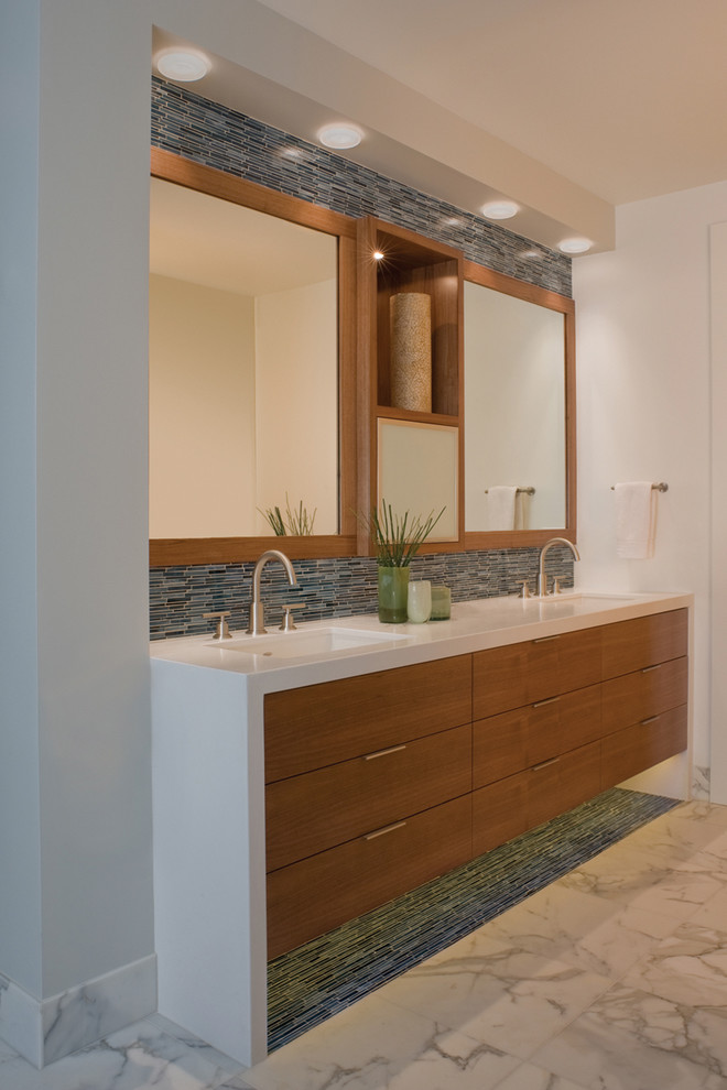 Diseño de cuarto de baño actual con lavabo bajoencimera, armarios con paneles lisos, puertas de armario de madera oscura, baldosas y/o azulejos azules y azulejos en listel