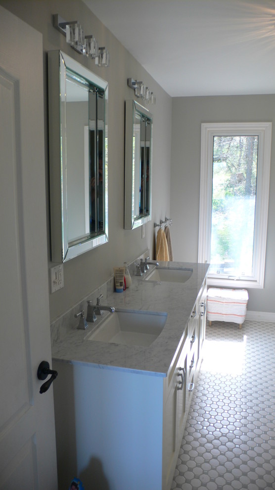 Inredning av ett modernt stort badrum, med släta luckor, vita skåp, ett platsbyggt badkar, en dusch/badkar-kombination, en toalettstol med separat cisternkåpa, vit kakel, keramikplattor, grå väggar, klinkergolv i keramik, ett undermonterad handfat, marmorbänkskiva, grått golv och dusch med gångjärnsdörr