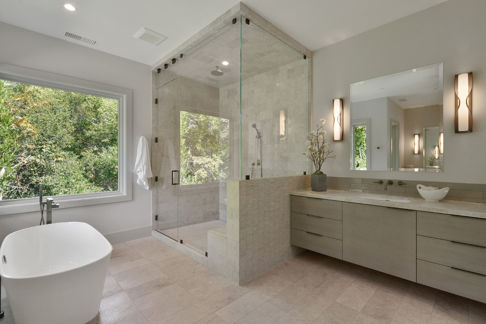 Inspiration for a contemporary ensuite bathroom in San Francisco with flat-panel cabinets, light wood cabinets, a freestanding bath, a corner shower, beige tiles, grey walls, a submerged sink, beige floors, a hinged door and beige worktops.