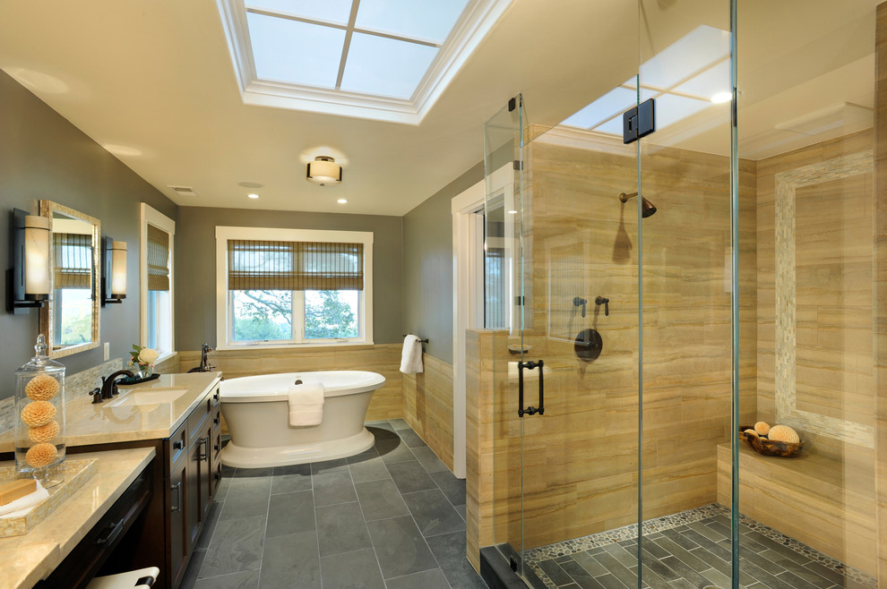 Cette photo montre une salle de bain tendance en bois foncé avec un lavabo encastré, un placard avec porte à panneau encastré, une baignoire indépendante, un carrelage beige, un espace douche bain et un sol gris.