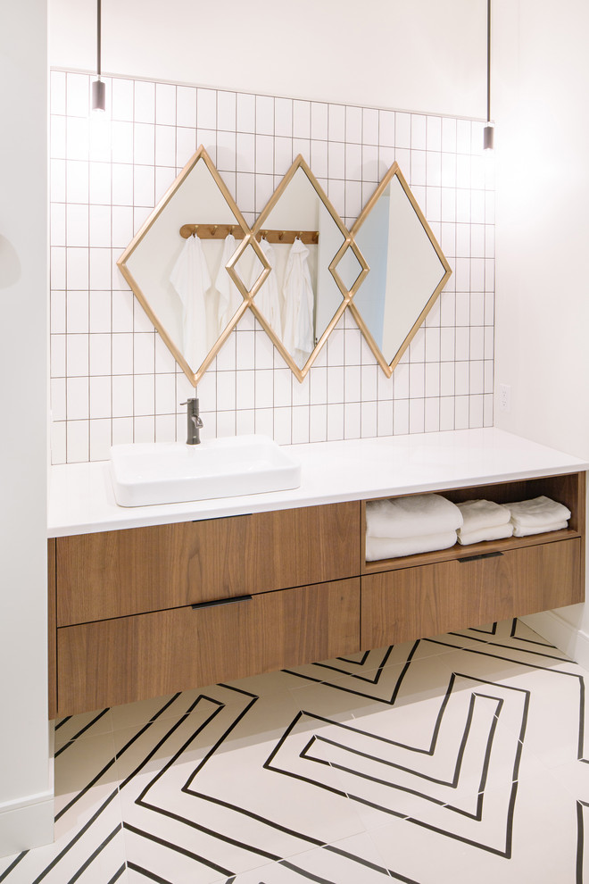 Пример оригинального дизайна: главная ванная комната в современном стиле с плоскими фасадами, фасадами цвета дерева среднего тона, белой плиткой, белыми стенами, настольной раковиной, разноцветным полом и белой столешницей