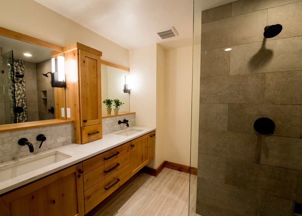 Bathroom - mid-sized craftsman master gray tile and marble tile porcelain tile and beige floor bathroom idea in Portland with shaker cabinets, medium tone wood cabinets, a wall-mount toilet, beige walls, a trough sink and quartzite countertops
