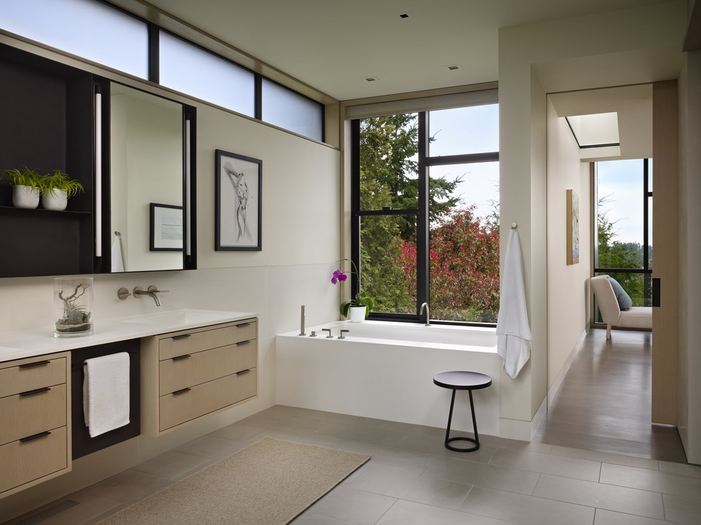 Идея дизайна: ванная комната в стиле модернизм с плоскими фасадами, светлыми деревянными фасадами и полновстраиваемой ванной