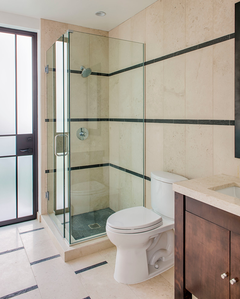 Medium sized traditional shower room bathroom in Los Angeles with a corner shower, stone tiles, beige walls, limestone flooring, medium wood cabinets, a two-piece toilet, beige tiles, a submerged sink, limestone worktops, beige floors and a hinged door.