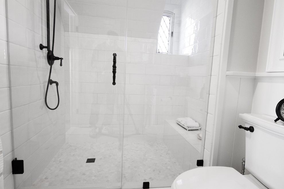 Inredning av ett modernt stort en-suite badrum, med luckor med profilerade fronter, vita skåp, ett undermonterat badkar, en hörndusch, en toalettstol med separat cisternkåpa, vit kakel, tunnelbanekakel, beige väggar, skiffergolv, ett undermonterad handfat, bänkskiva i kvartsit, beiget golv och dusch med gångjärnsdörr