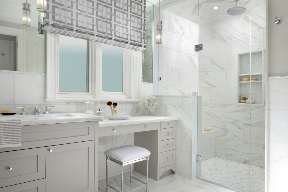 This is an example of a medium sized traditional ensuite bathroom in Toronto with shaker cabinets, grey cabinets, a freestanding bath, a corner shower, a one-piece toilet, white tiles, marble tiles, grey walls, marble flooring, a submerged sink, marble worktops, white floors, a hinged door and white worktops.