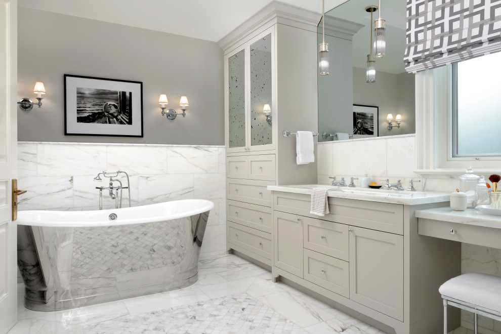 Exempel på ett mellanstort klassiskt vit vitt en-suite badrum, med skåp i shakerstil, grå skåp, ett fristående badkar, vit kakel, marmorkakel, grå väggar, marmorgolv, ett undermonterad handfat, marmorbänkskiva och vitt golv
