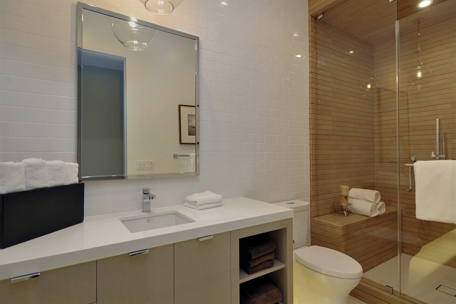Contemporary shower room bathroom in San Francisco with flat-panel cabinets, beige cabinets, a corner shower, a two-piece toilet, white tiles, ceramic tiles, white walls, ceramic flooring, a built-in sink and marble worktops.