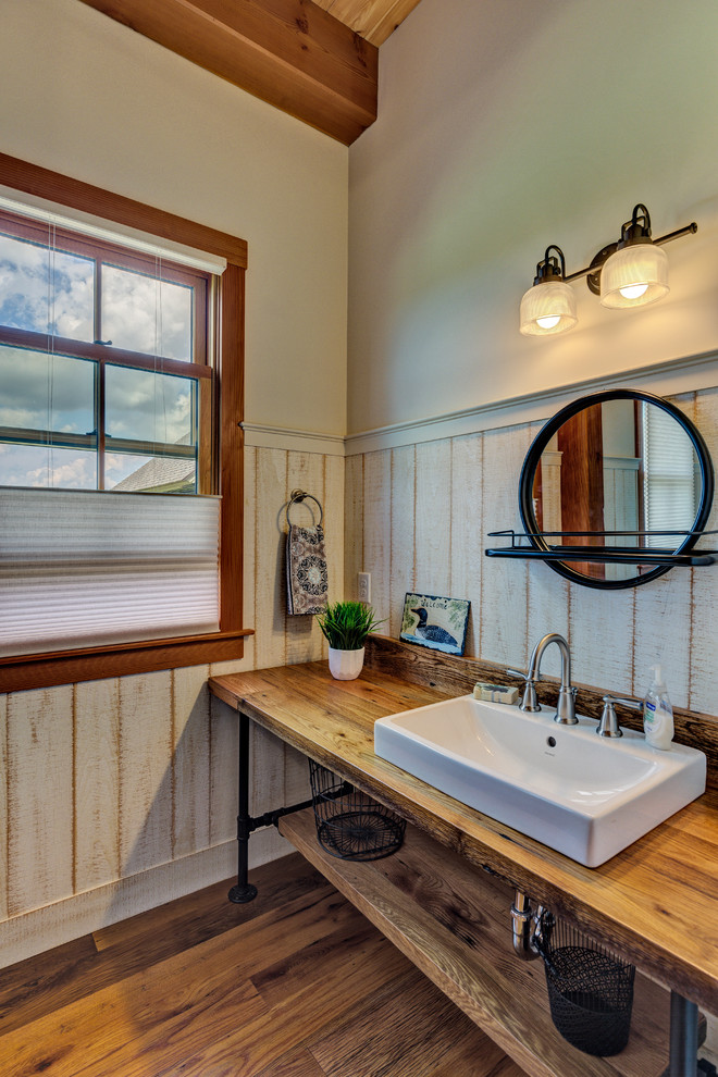 Modelo de cuarto de baño de estilo de casa de campo pequeño con armarios abiertos, paredes grises, suelo de madera oscura, lavabo sobreencimera, encimera de madera, suelo marrón y encimeras marrones