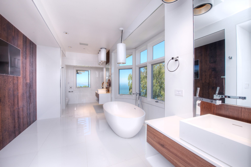 Diseño de cuarto de baño principal mediterráneo grande con lavabo sobreencimera, armarios con paneles lisos, puertas de armario de madera oscura, encimera de cuarzo compacto, bañera exenta, paredes blancas y suelo de mármol