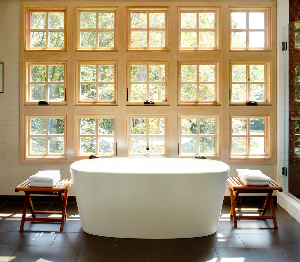 Inredning av ett modernt stort en-suite badrum, med ett fristående badkar, beige väggar, släta luckor, skåp i mellenmörkt trä, en hörndusch, beige kakel, marmorkakel, klinkergolv i porslin, marmorbänkskiva och brunt golv