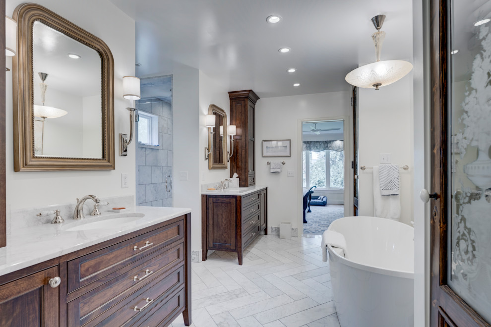 This is an example of a large traditional ensuite bathroom in Denver with beaded cabinets, dark wood cabinets, a freestanding bath, white walls, a submerged sink, a single sink and a built in vanity unit.