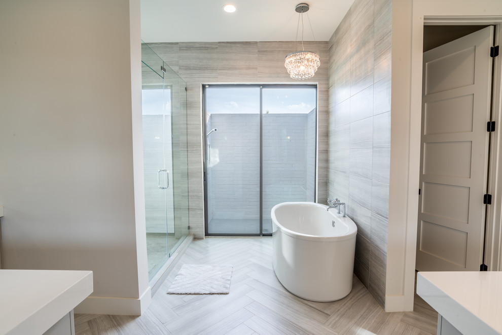 Large traditional ensuite bathroom in Houston with a freestanding bath, an alcove shower, grey tiles, ceramic tiles, white walls, light hardwood flooring, marble worktops, grey floors and a hinged door.