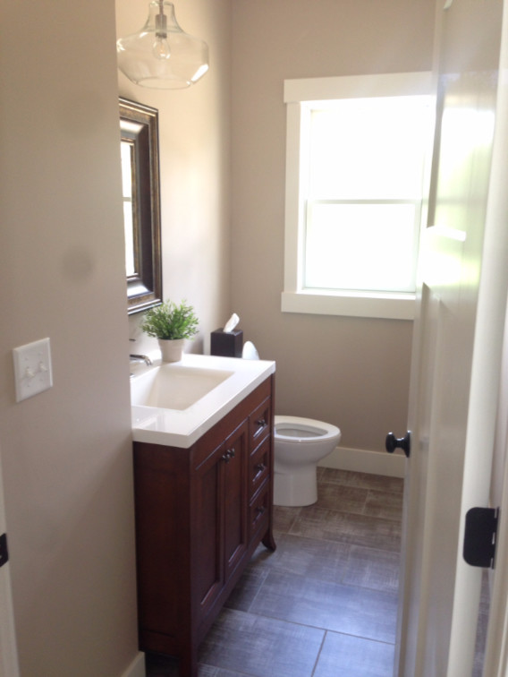 Aménagement d'une salle de bain principale campagne en bois foncé de taille moyenne avec un placard à porte shaker, un mur beige, un sol en carrelage de porcelaine, un lavabo encastré, un plan de toilette en surface solide et un sol beige.