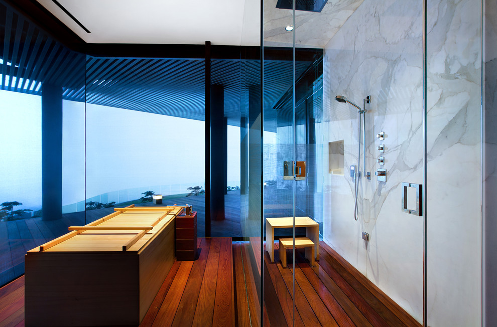 Foto de cuarto de baño principal actual grande con bañera japonesa, ducha esquinera, paredes blancas y suelo de madera en tonos medios