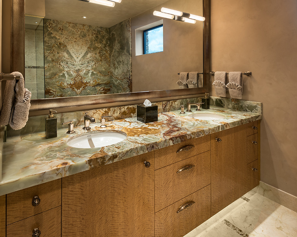 This is an example of a large contemporary ensuite bathroom in Other with flat-panel cabinets, light wood cabinets, a two-piece toilet, beige tiles, stone tiles, beige walls, marble flooring, a submerged sink and onyx worktops.