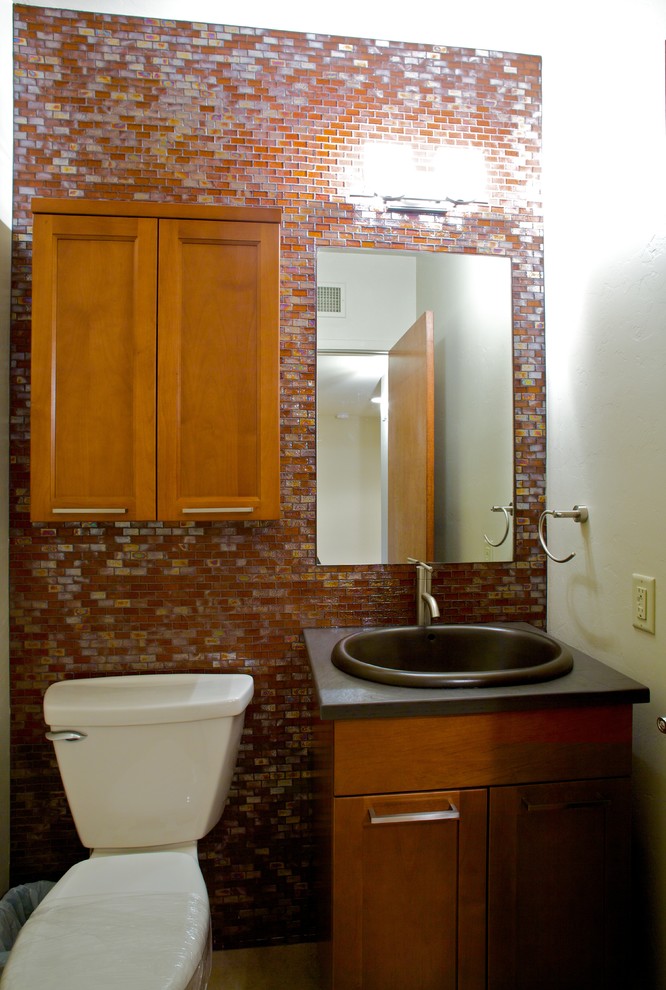 Immagine di una stanza da bagno minimal con lavabo da incasso, ante in stile shaker, ante in legno scuro, top in superficie solida, WC a due pezzi, piastrelle multicolore, piastrelle di vetro e pareti bianche
