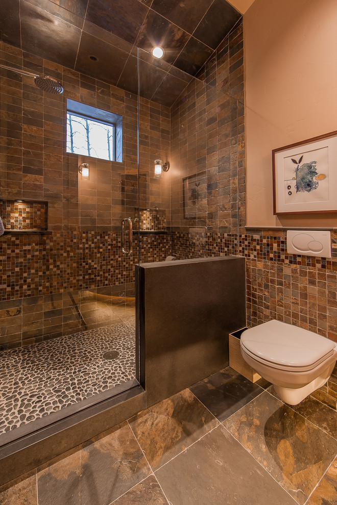 Mountain style brown tile brown floor alcove shower photo in Denver with a wall-mount toilet
