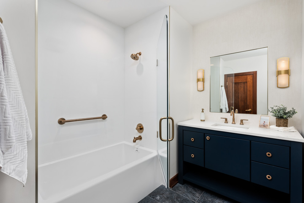 This is an example of a large traditional ensuite bathroom in Chicago with flat-panel cabinets, blue cabinets, an alcove bath, a shower/bath combination, a one-piece toilet, white tiles, porcelain tiles, white walls, porcelain flooring, a submerged sink, engineered stone worktops, blue floors, a hinged door, white worktops, an enclosed toilet, a single sink and a freestanding vanity unit.