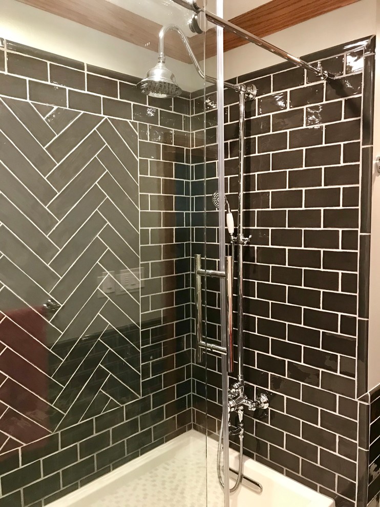 Medium sized urban family bathroom in Other with freestanding cabinets, white cabinets, an alcove bath, a shower/bath combination, a one-piece toilet, black tiles, metro tiles, grey walls, porcelain flooring, a submerged sink, marble worktops, multi-coloured floors, a sliding door and white worktops.