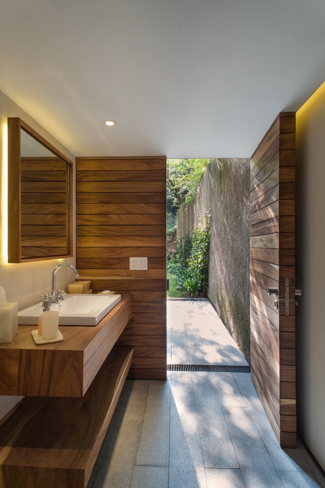Diseño de cuarto de baño actual con lavabo sobreencimera y espejo con luz