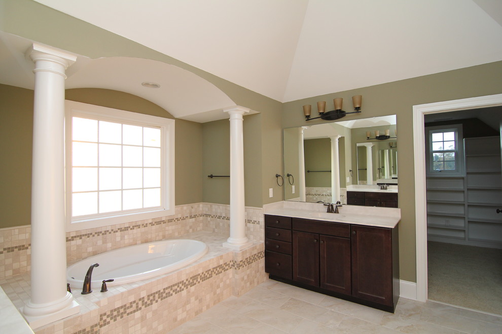 Large elegant master beige tile and ceramic tile ceramic tile bathroom photo in Raleigh with an integrated sink, recessed-panel cabinets, dark wood cabinets, a one-piece toilet and green walls