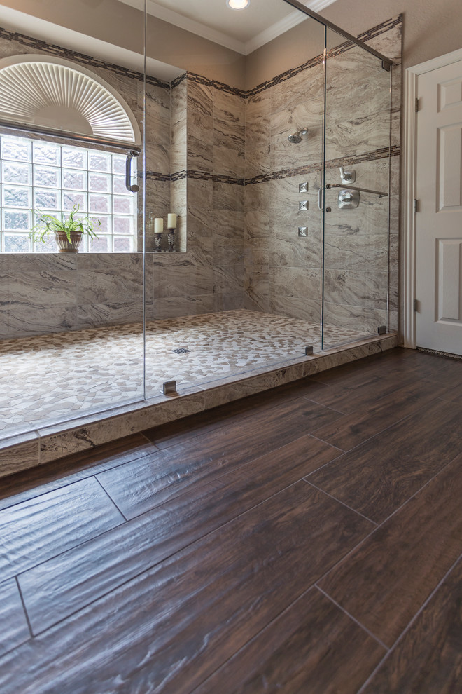 Пример оригинального дизайна: большая главная ванная комната в стиле неоклассика (современная классика) с двойным душем, коричневой плиткой, керамогранитной плиткой, полом из галечной плитки, коричневым полом и душем с распашными дверями