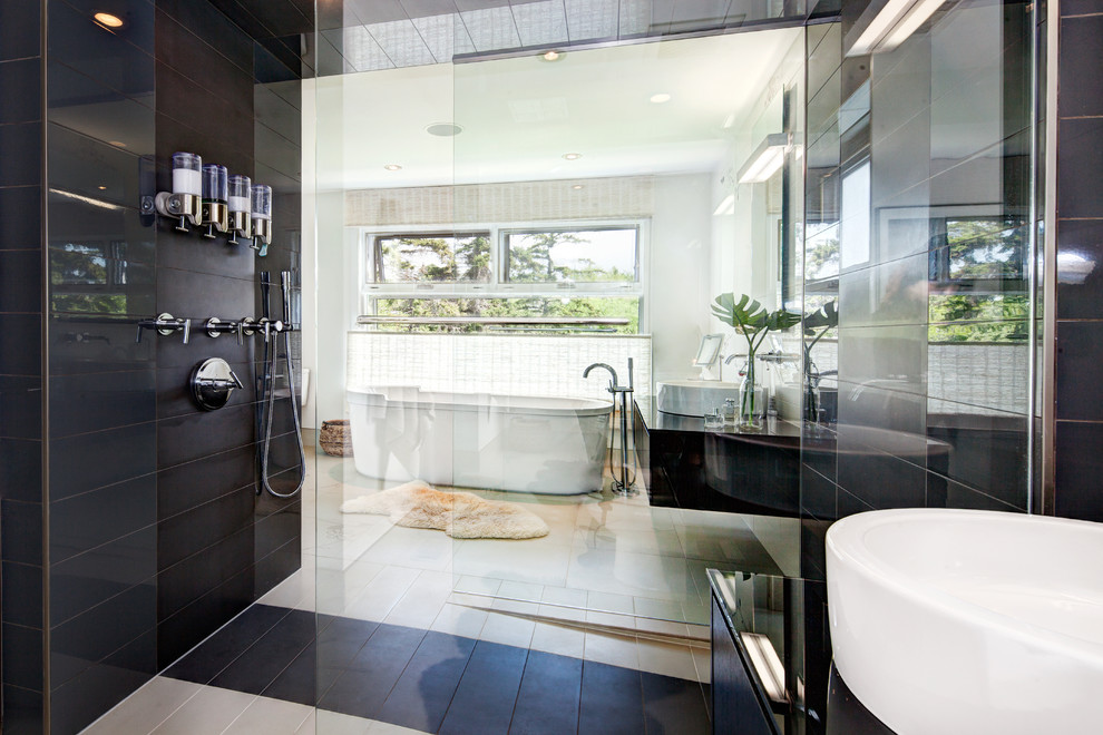 Inspiration for a large contemporary ensuite bathroom in Calgary with a freestanding bath, a vessel sink, flat-panel cabinets, dark wood cabinets, quartz worktops, a walk-in shower, a one-piece toilet, white tiles, porcelain tiles, white walls, ceramic flooring and an open shower.