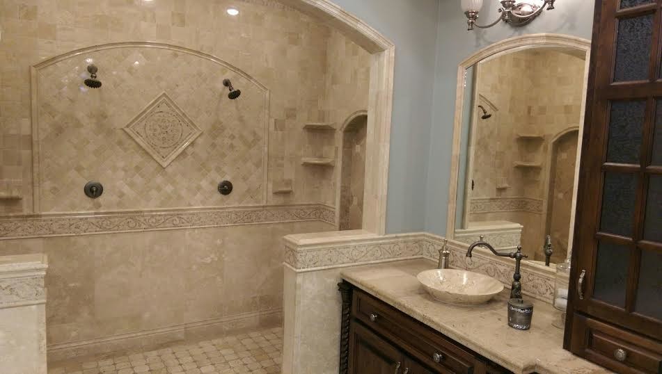 Cette image montre une grande salle de bain principale traditionnelle en bois foncé avec un placard avec porte à panneau surélevé, une douche double, WC séparés, un carrelage beige, des carreaux en terre cuite, un mur bleu, un sol en travertin, un plan de toilette en marbre et une vasque.