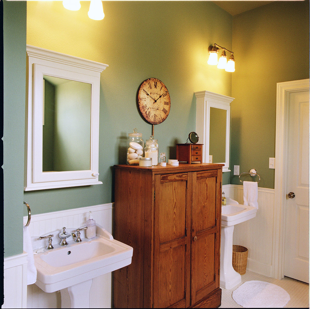 На фото: ванная комната в стиле кантри с раковиной с пьедесталом и зелеными стенами с