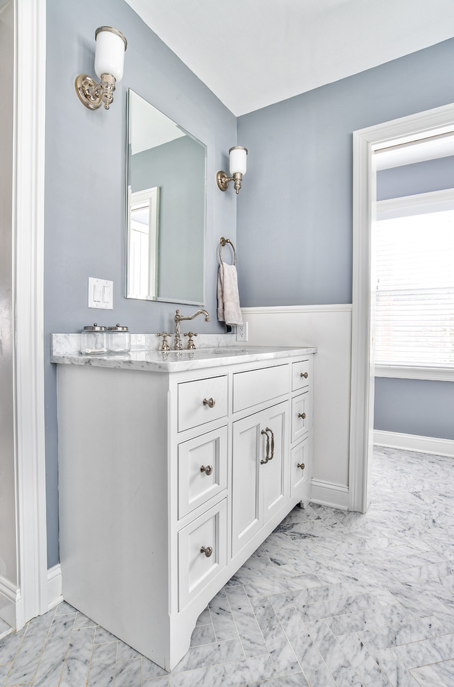 Large elegant master marble floor and white floor bathroom photo in New York with beaded inset cabinets, white cabinets, a two-piece toilet, gray walls, an undermount sink, marble countertops, a hinged shower door and white countertops