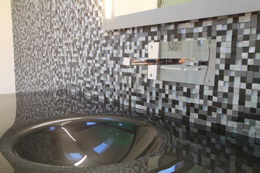 Inspiration for a contemporary black and white tile bathroom remodel in Philadelphia with glass countertops