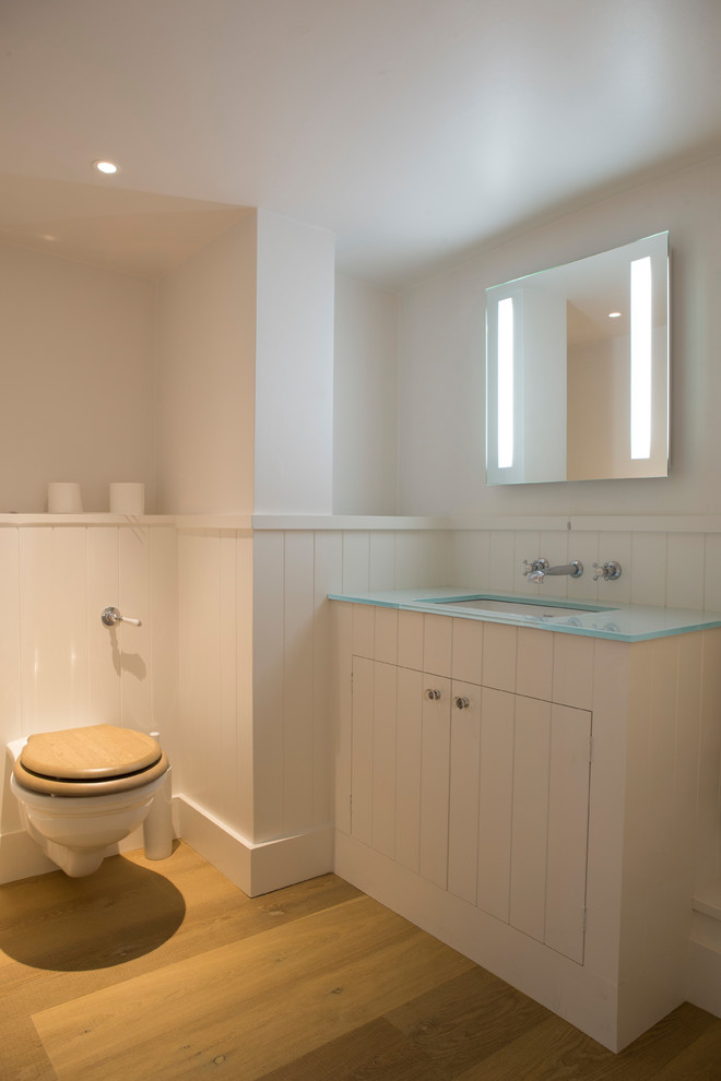 Design ideas for a medium sized traditional family bathroom in Oxfordshire with a one-piece toilet, white tiles, white walls, light hardwood flooring, a built-in sink, shaker cabinets, white cabinets, recycled glass worktops and turquoise worktops.