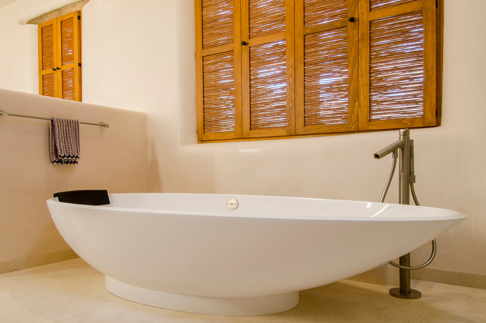 Foto de cuarto de baño principal bohemio de tamaño medio con bañera exenta y paredes beige