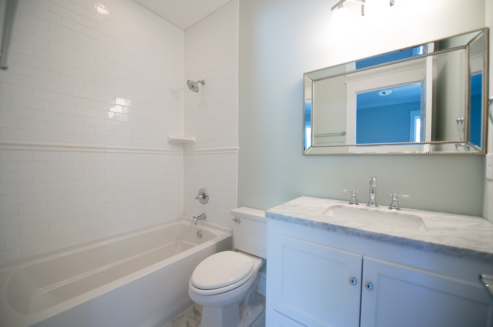 Пример оригинального дизайна: ванная комната в викторианском стиле с фасадами в стиле шейкер, белыми фасадами, ванной в нише, душем над ванной, раздельным унитазом, белой плиткой, керамической плиткой, серыми стенами, мраморным полом, врезной раковиной и мраморной столешницей
