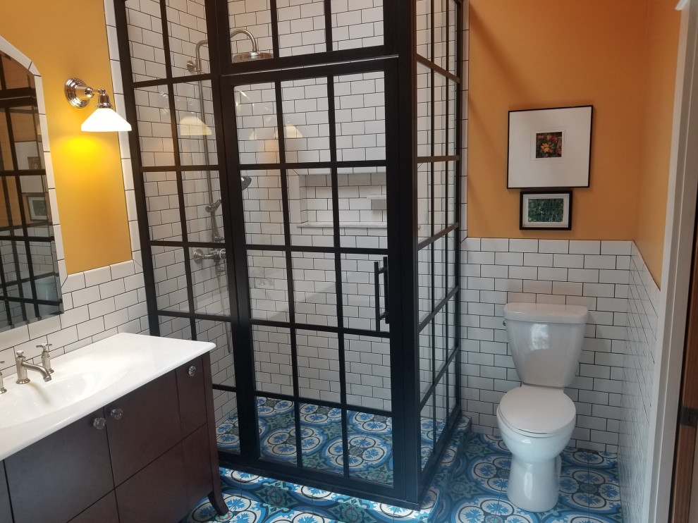 Example of a large transitional master blue tile and cement tile blue floor, single-sink and cement tile floor bathroom design in Little Rock with brown cabinets, orange walls, a hinged shower door, white countertops, a built-in vanity, an integrated sink and solid surface countertops