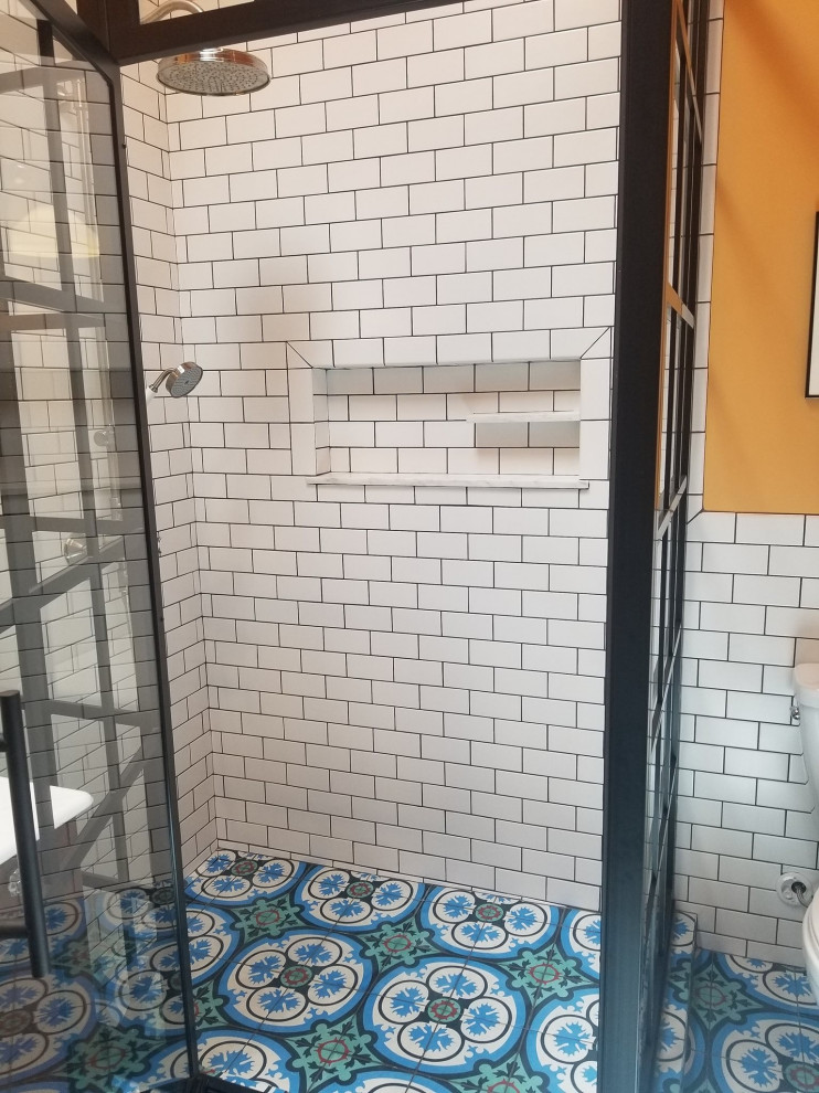 Example of a large transitional master blue tile and cement tile blue floor, single-sink and cement tile floor bathroom design in Little Rock with brown cabinets, orange walls, a hinged shower door, white countertops and a built-in vanity
